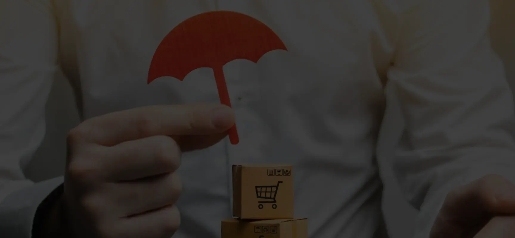 Person holding a small red umbrella over stacked cardboard boxes with shopping cart icons.