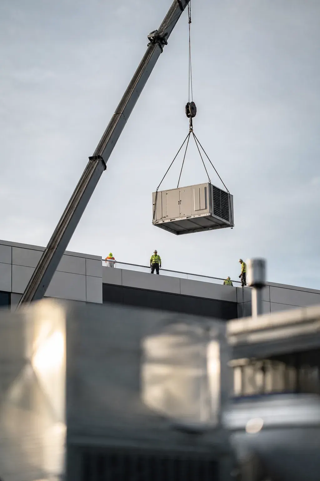 Crane lifting a rooftop HVAC unit
