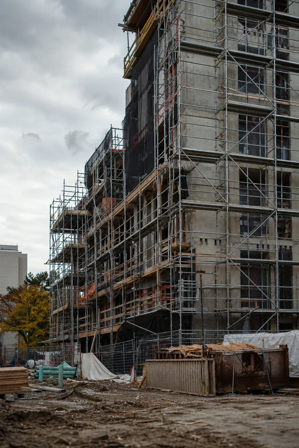 Mid-rise building under construction wrapped in scaffolding
