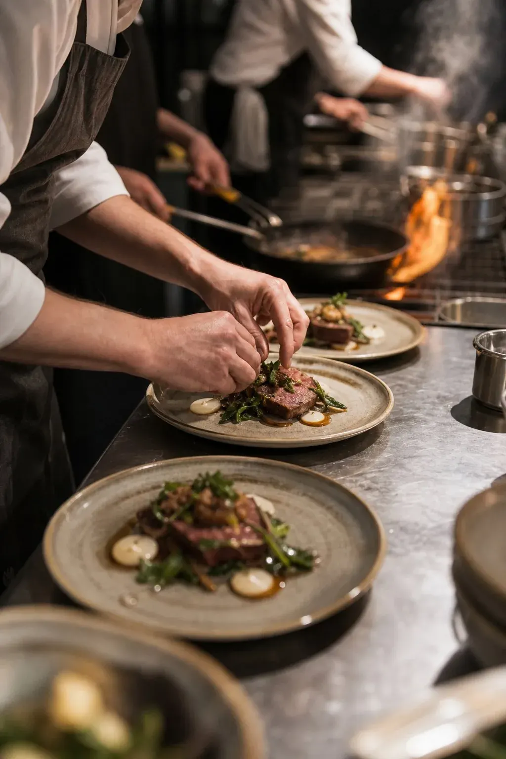 Chef plating dishes on a busy kitchen line